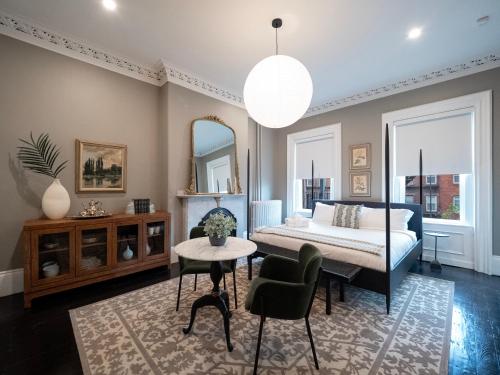 a bedroom with a bed and a table and chairs at The Chester Hotel in Boston
