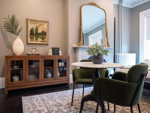 a dining room with a table and chairs and a mirror at The Chester Hotel in Boston