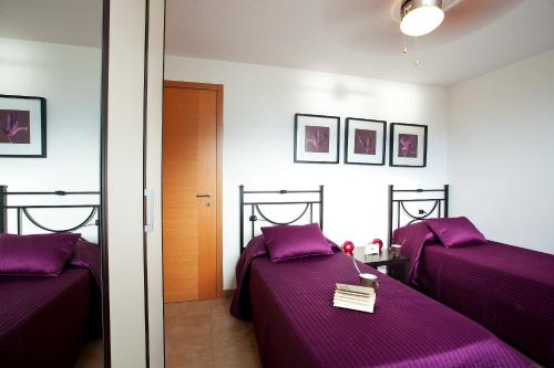 RezzonicoにあるResidenza Romina Apartmentのベッドルーム(紫のシーツを使用したベッド2台付)
