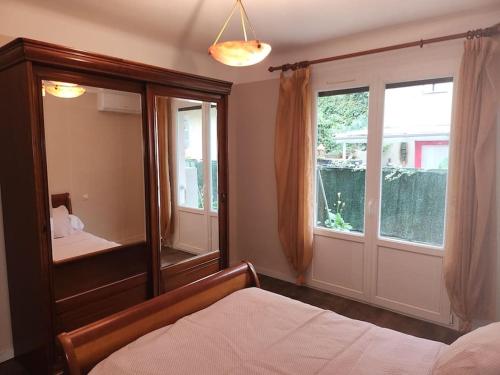 - une chambre avec un miroir, un lit et une fenêtre dans l'établissement Résidence Centrale Appartement 3 pièces Garage et jardin, à Amélie-les-Bains-Palalda