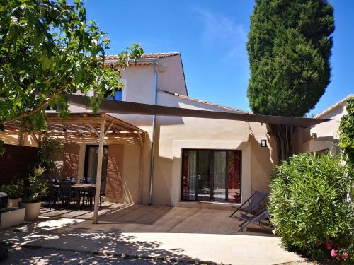 une maison avec un patio avec une table et des chaises dans l'établissement Gîtes Amour de Provence, à Châteaurenard