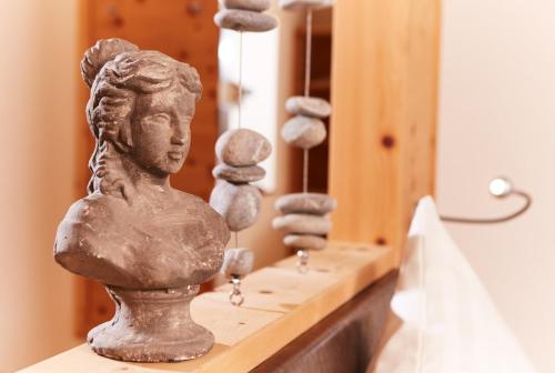 a stone bust of a girl sitting on a counter with rocks at Hotel Riederhof- Urlaub mit WAU! in Ried im Oberinntal