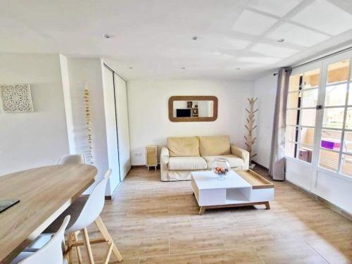 un salon avec un canapé et une table dans l'établissement Hameau des pins - Plage - Piscine - Wifi - Clim, à Saint-Raphaël