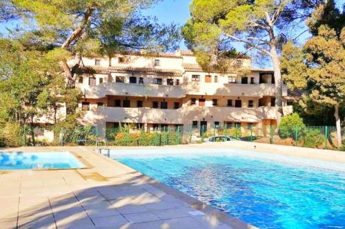 - une vue sur l'extérieur d'une grande maison avec une piscine dans l'établissement Hameau des pins - Plage - Piscine - Wifi - Clim, à Saint-Raphaël