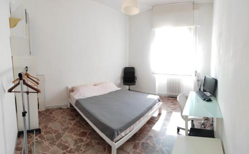 a bedroom with a bed and a desk and a television at White house in Bari