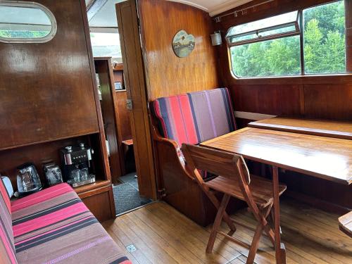une salle à manger avec une table et une chaise dans l'établissement Séjour insolite sur un bateau, à Louveciennes