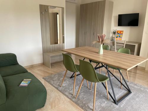 a living room with a wooden table and green chairs at Dimora Valentina in Tricase
