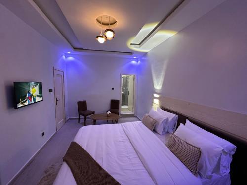 a bedroom with a large bed with purple lighting at Resid'homes Appart'hotel SaintLouis in Saint-Louis