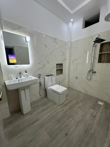 a white bathroom with a sink and a toilet at Resid'homes Appart'hotel SaintLouis in Saint-Louis