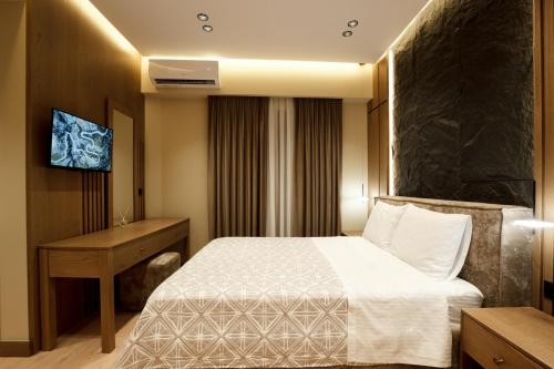 a hotel room with a bed and a desk at Sunny Hill Boutique Hotel in Gjirokastër