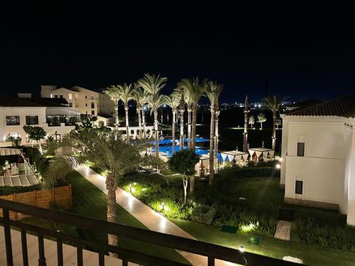 a view of a resort at night with palm trees at Address golf ,marassi in El Alamein