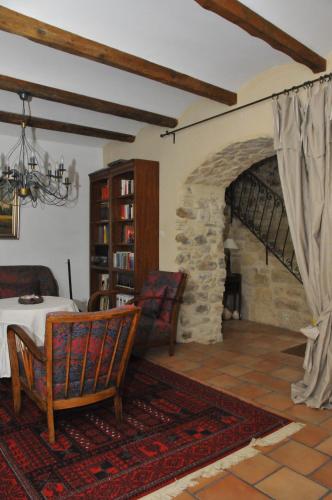 - un salon avec une table et une cheminée en pierre dans l'établissement Maison L'Authentique, à La Capelle-et-Masmolène