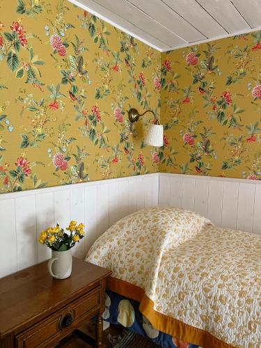 a bedroom with a bed with floral wallpaper at Muhu Tõnise Talu in Liiva