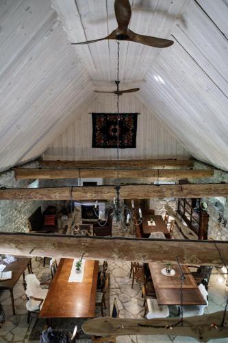 an attic room with wooden tables and a ceiling at Muhu Tõnise Talu in Liiva