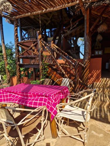 a table and chairs with a pink blanket on it at MONKEY MOUNTAIN LODGE in Mtende