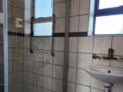 a bathroom with a shower and a sink at Mzimkhulu Ranch & Resort in Dinokeng Game Reserve