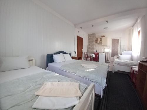a white room with two beds and a bathroom at Ambient Apartments in Struga