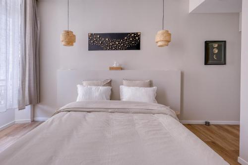 a white bedroom with a large bed with white pillows at Short Time Suites Toulon Centre 1 "LE STUDIO" Check-in auto in Toulon