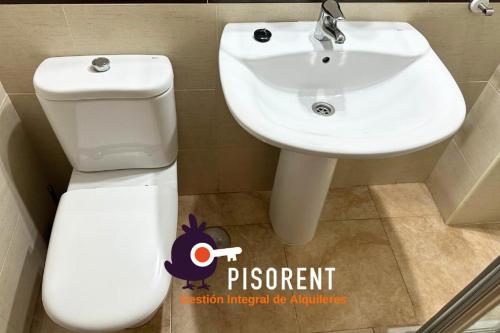 a bathroom with a white sink and a toilet at Sol y Mar in Almería