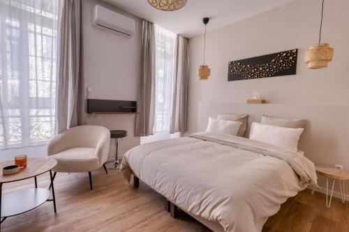 a bedroom with a large white bed and a chair at Short Time Suites Toulon Centre 1 "LE STUDIO" Check-in auto in Toulon