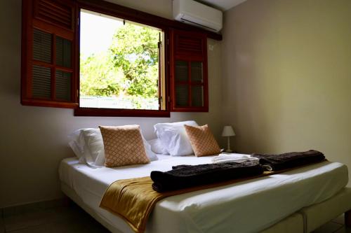 - une chambre avec un lit blanc et une fenêtre dans l'établissement Piscine, Plages Bois Jolan et du bourg, Jardin & Parking privés, Sainte-Anne - Villas Orchyd & Ka, à Sainte-Anne
