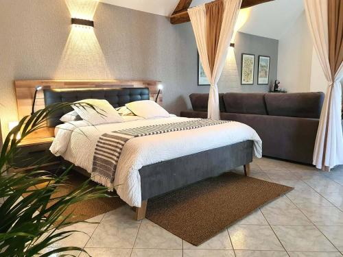 un dormitorio con una cama y un sofá en La Chambre des Châteaux, en Cellettes