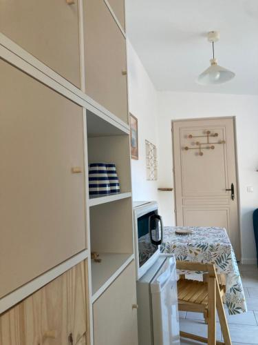 une petite cuisine avec une petite table et une petite cuisine avec une porte dans l'établissement Charmante maison proche La Rochelle, à La Jarrie