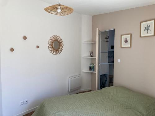 - une chambre avec un lit vert et un miroir dans l'établissement Charmante maison proche La Rochelle, à La Jarrie