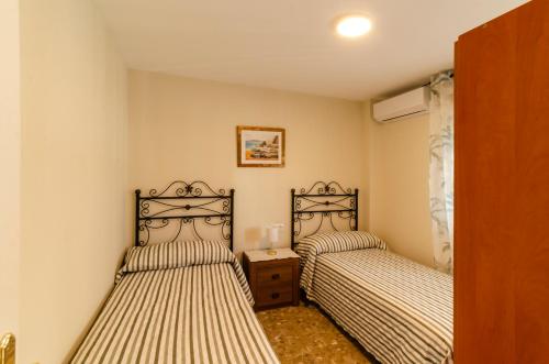 two beds in a small room with two beds sidx sidx sidx at El Atico de Andrea in Torre del Mar