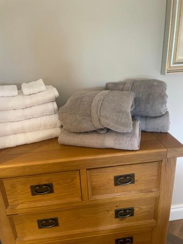 ein Stapel Handtücher auf einer Holzkommode in der Unterkunft Cabra Cottage in Kilcoo