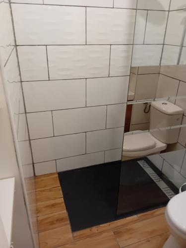 La salle de bains est pourvue de toilettes et d'un mur carrelé blanc. dans l'établissement Beauséjour, à Allevard