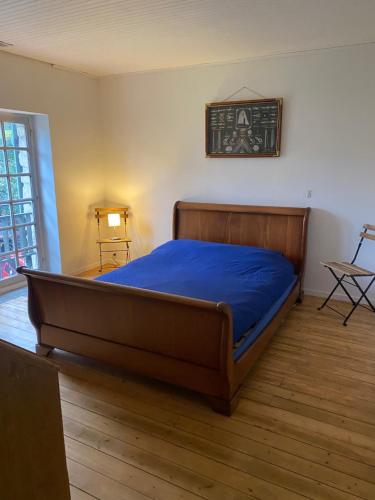une chambre avec un lit avec un couvre-lit bleu dans l'établissement Maison de caractère, conviviale, à Boissy-le-Cutté