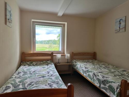 a bedroom with two beds and a window at Dom nad morzem w Pleśnej in Pleśna
