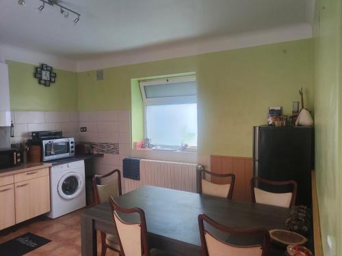 une cuisine avec une table et une cuisine avec un micro-ondes dans l'établissement Maison centre-ville, à Capdenac-Gare