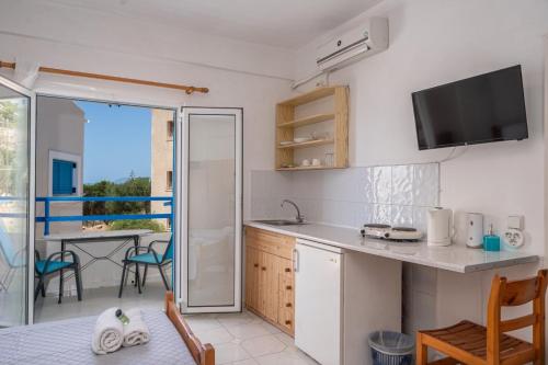 a kitchen with a sink and a table with chairs at Fiore Di Mare Studios in Lassi