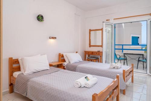 a bedroom with two beds and a room with a table at Fiore Di Mare Studios in Lassi