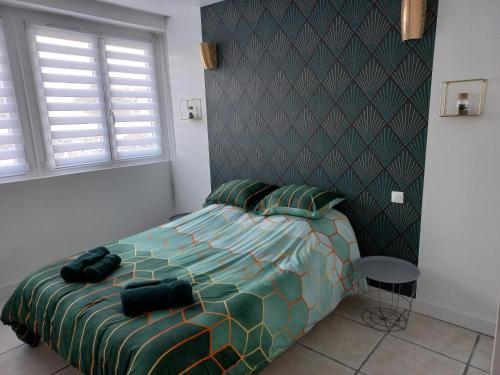 une chambre avec un lit avec une couette verte dans l'établissement Treportplage, au Tréport