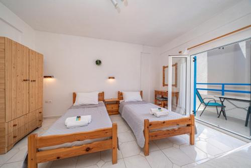 a bedroom with two beds and a balcony at Fiore Di Mare Studios in Lassi