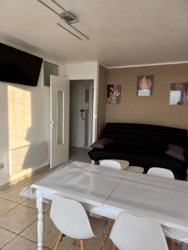 un salon avec une table et des chaises blanches dans l'établissement Treportplage, au Tréport