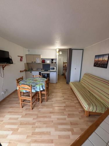 Cette chambre comprend une table, un lit et une cuisine. dans l'établissement Studio cabine 4 personnes, à Font-Romeu-Odeillo-Via