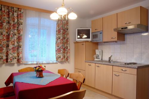 a kitchen with a table with a red table cloth at Gasthof Neumeister in Stumm