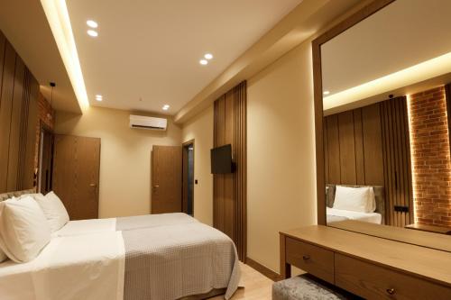 a bedroom with a bed and a large mirror at Sunny Hill Boutique Hotel in Gjirokastër