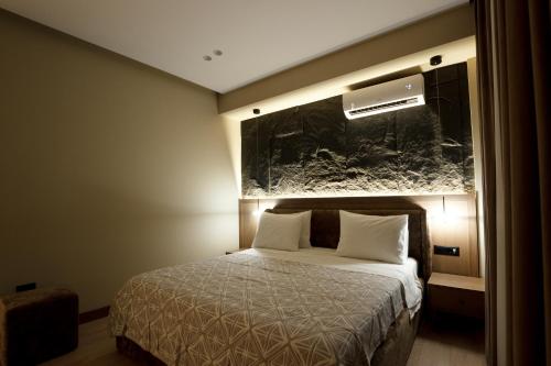 a bedroom with a bed and a painting on the wall at Sunny Hill Boutique Hotel in Gjirokastër
