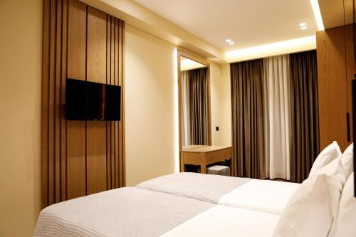 a hotel room with a bed and a desk at Sunny Hill Boutique Hotel in Gjirokastër