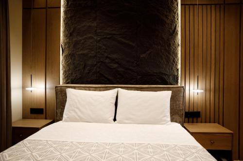 a bedroom with a large bed with white sheets and pillows at Sunny Hill Boutique Hotel in Gjirokastër