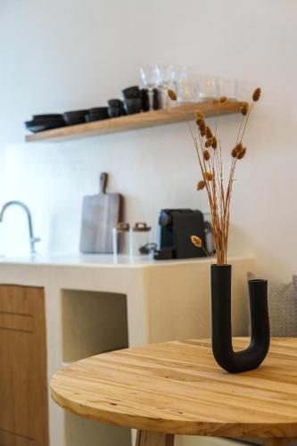a wooden table with a vase with flowers on it at Villa Karterados Suites in Karterados