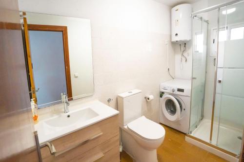 a bathroom with a toilet sink and a washing machine at House Los Angeles in Chulilla