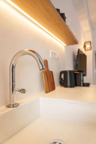 a kitchen counter with a sink with a wooden holder at Villa Karterados Suites in Karterados