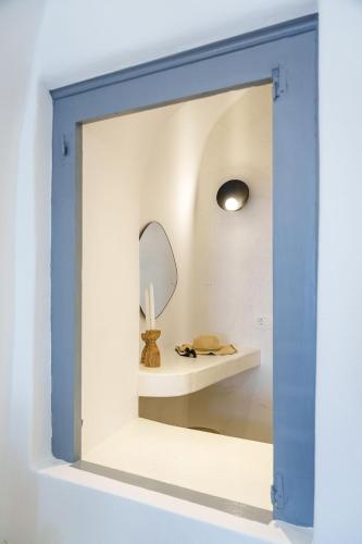 a mirror in a white room with a white table and a mirror at Villa Karterados Suites in Karterados