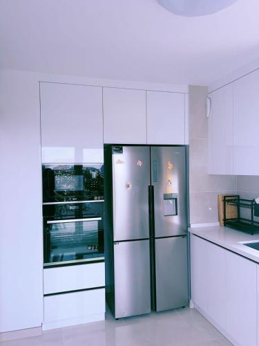 d'un réfrigérateur dans une cuisine avec des placards blancs. dans l'établissement Vu Seine Appartement Duplex, à Ivry-sur-Seine